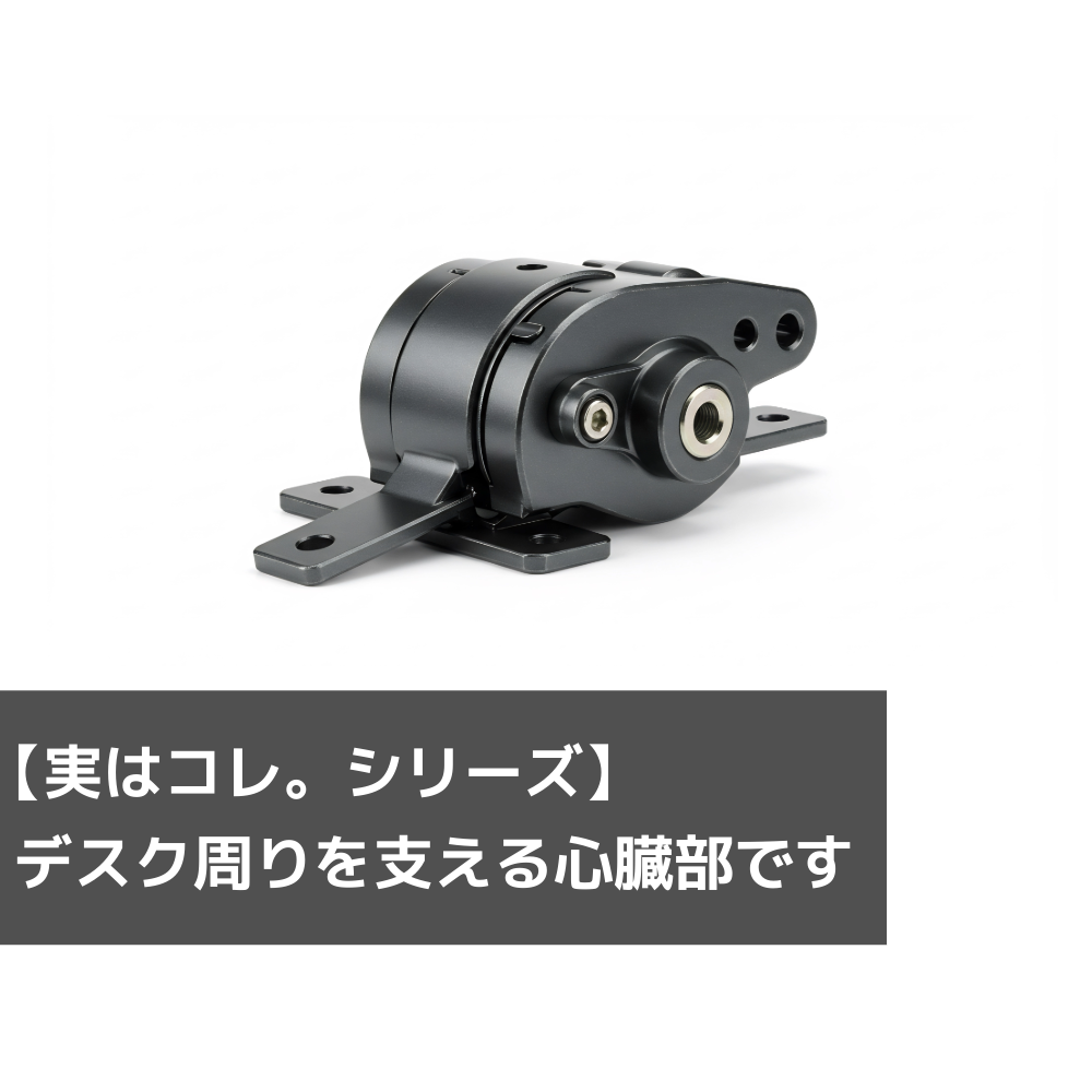 白背景に置かれた黒い金属製部品の写真。下部にグレーの帯が敷かれ、「【実はコレ、シリーズ】デスク周りを支える心臓部です」という白い文字が重なっている。
